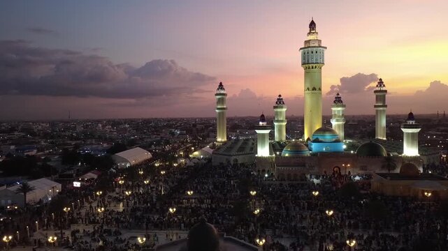 SENEGAL - 10.23.2025 - Beautiful aerial pan of the Great Mosque of Touba at night during a religious pilgrimage.