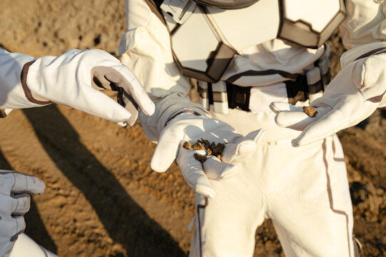 Explorers collect samples on an extraterrestrial landscape during a scientific mission