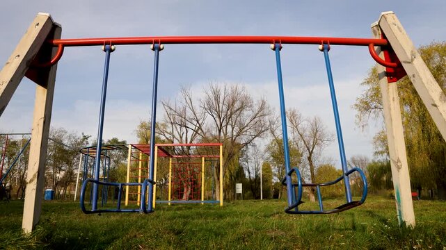 bottom view of an empty children's swing without seats swings by inertia
