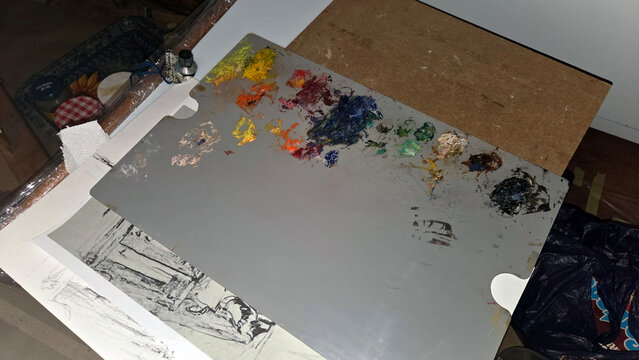 Creative workspace with paint palette and sketches in artist's studio