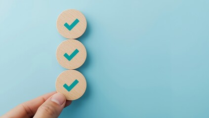 Hand placing a wooden circle with a check mark symbolizing approval and task completion on a blue background