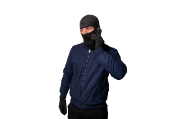 Thief wearing a balaclava mask and black gloves making an urgent phone call on a smartphone, planning crime
