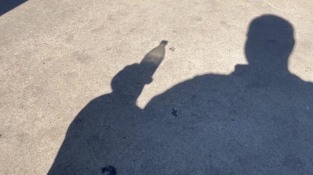Man in shadow drinking a soda water in silhouette
