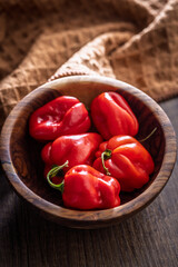 Red chili pepper habanero in bowl on wooden table.