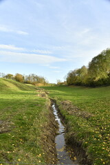 Ruisselet coulant paisiblement dans une prairie en automne à Écaussinnes-Lalaing (Soignies)