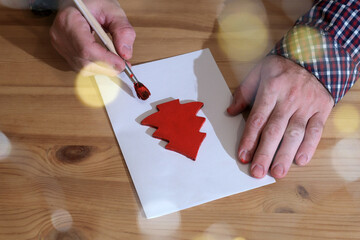 Hands painting christmas tree shape for holiday. preparing for the new year