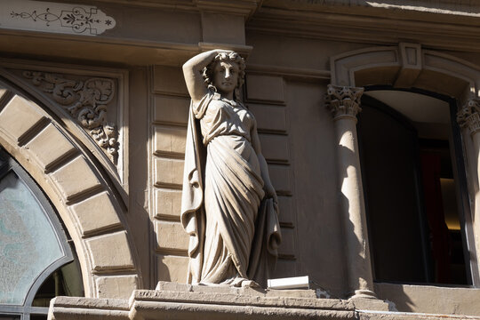 Classical-style statue of a woman on a historic building facade in Istanbul