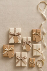 Flat lay of neutral-toned gift boxes with ribbon bows and tags