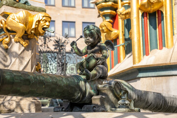 Fototapeta premium Schöner Brunnen in Nuremberg’s Hauptmarkt, a famous Gothic-style fountain inspired by a 14th-century spire, captured in bright daylight in the historic market square.
