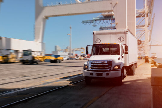 Fast Delivery Logistics: Box Truck in Motion Blur at Container Port