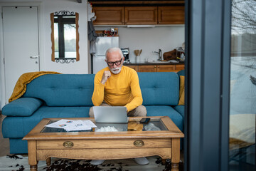 Senior man working from home using laptop