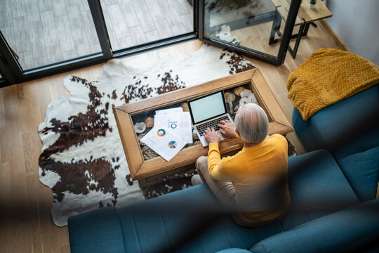 Senior man working from home reviewing financial documents - Powered by Adobe