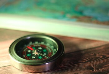 close up of a compass and atlas maps travel navigation
