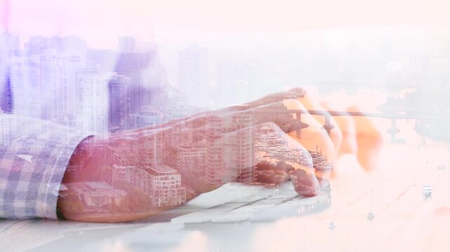 Double exposure of male hands typing on the keyboard against the city