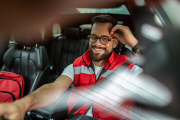 Male paramedic smiling while driving emergency medical response vehicle