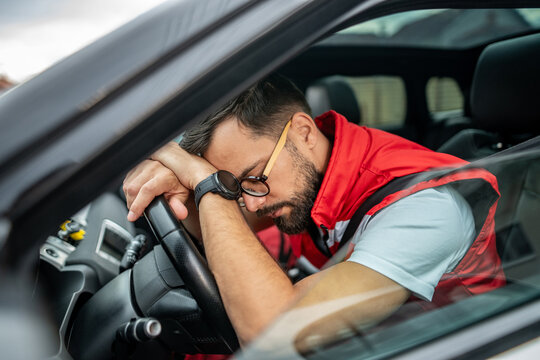 Tired man sleeping in car feeling fatigue stress