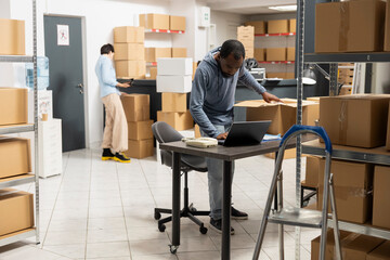 Black warehouse worker handling cargo and shipping logistics, coordinating inventory and hand...