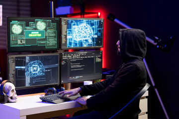 Hacker typing on keyboard, running neural network software to breach company security and open...