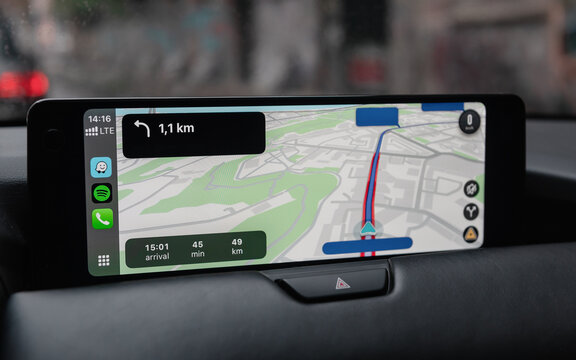 Waze navigation on screen in modern car. Wide aspect ratio screen in car interior - close-up shot of infotainment system with Apple Carplay screencast. Kyiv, Ukraine - October 02 2025
