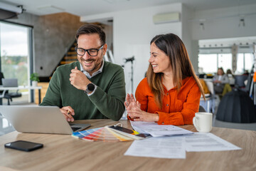 Fototapeta premium Smiling business colleagues collaborating on design project in office
