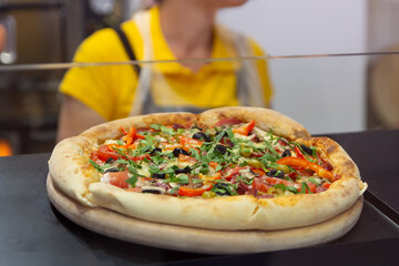 Obraz premium Pizza in the pizzeria window and cook