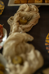 Detalle decorativo con vela y tela beige sobre una mesa navideña. Imagen cálida que transmite elegancia, calma y ambiente festivo.