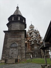 The iconic wooden Bell Tower standing next to the 22-domed Church of the Transfiguration, showcasing the central architectural ensemble of Kizhi Pogost
