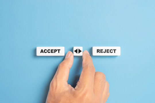 Male hand holds a dice with arrow icon between the options of accept or reject