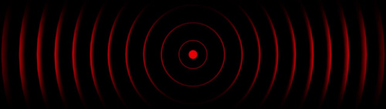 Concentric red glowing circles radiating outwards with a central red dot on a black background abstract
