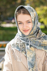 Portrait of a young beautiful woman with a scarf on her head