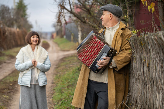The accordionist is the best guy in the village. Autumn outdoor.