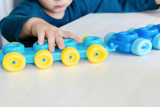 Little child boy playing with mosaic constructor.Baby building figures of blocks.Children logic,fine motor skills development.Early sensory education.Activities Montessori