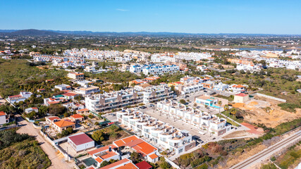 Naklejka premium aerial, Fuzeta, Portugal, condominio Stylish apartments with ocean views, Modern flats featuring sunlit balconies facing sea, Contemporary dwellings offering panoramic