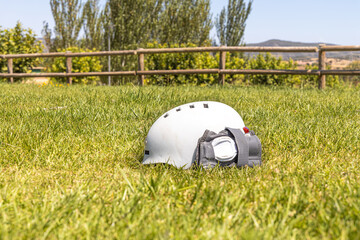 A white helmet and A gray wrist guard on the green grass background