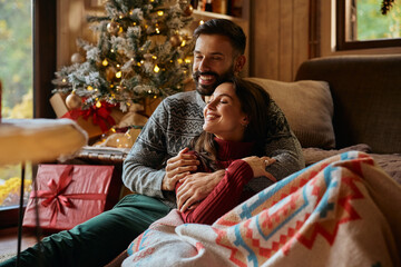 Obraz premium Young happy couple spending Christmas together at home.