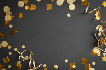 frame of gold streamers and confetti on a black background with copy space