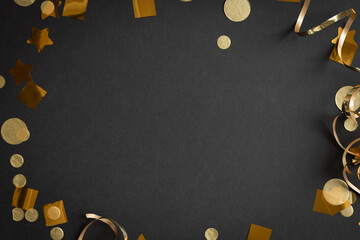 Frame of gold streamers and confetti on black