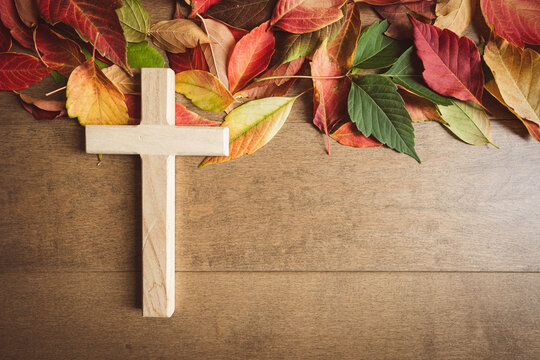 Wood cross with autumn leaves