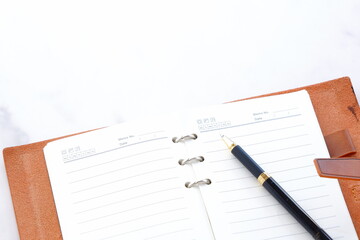 Opened schedule planner, diary, notebook on white table
