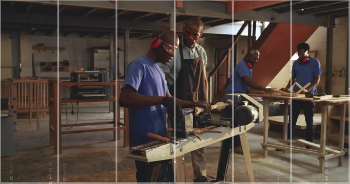 Operating mid adult woodworker apprentice shaping spindle on wood lathe inside workshop, with tools
