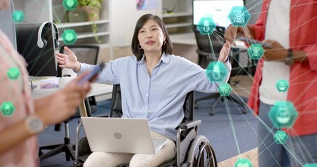 Gesturing woman in wheelchair in light-blue shirt presenting at office, with laptop and AR graphics