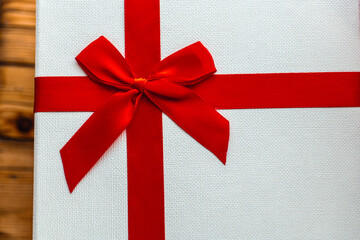 elegant gift packaging, red ribbon on white box, minimalist top view of gift box with bow, simple flat arrangement showcasing satin ribbon on gift box