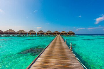 Wooden deck goes to bungalows. Tropical island beach landscape exotic shore coast. Tranquil closeup calm sea water waves. Summer vacation, holiday amazing nature. Relax paradise, Maldives.