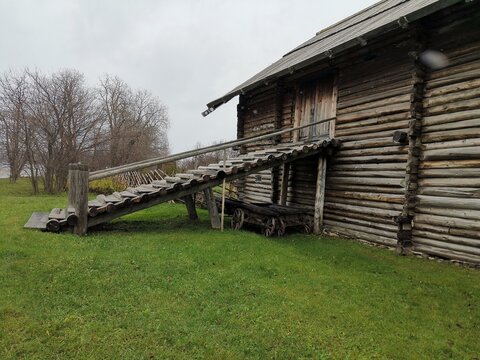 Old wooden ramp and carts beside the historic Yakovlev House on Kizhi Island, Russia, showcasing traditional northern architecture.