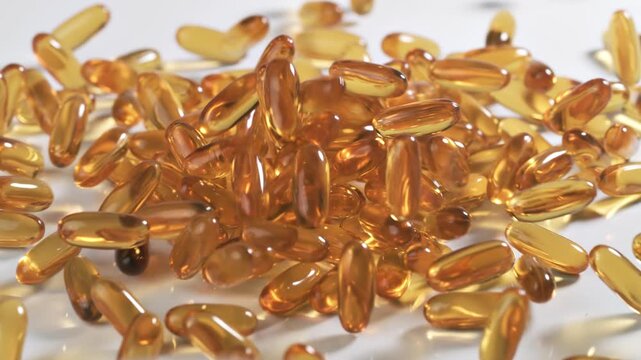 Vitamins and supplements fall onto a table in slow motion.