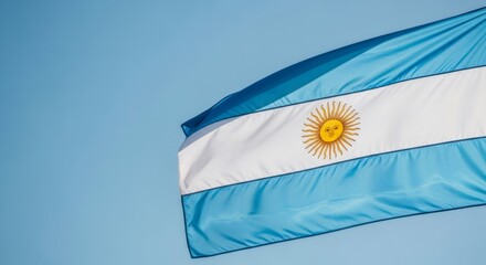 Argentina national flag against blue sky, waving gracefully in the wind for patriotic celebration or Independence Day template