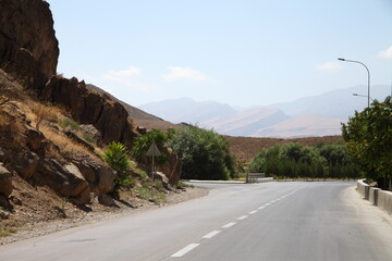 A mountain road beneath rugged arid slopes near Markau Mountain by Ashgabat, Turkmenistan. g.