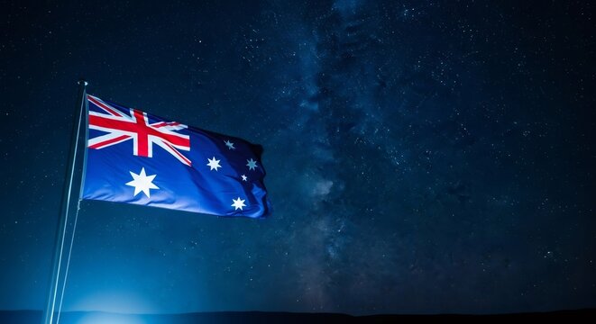 Australian flag waving brightly under a dark night sky filled with a starry milky way. Patriotism concept for national holiday. - Powered by Adobe