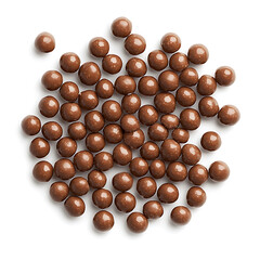 Chocolate cereal balls are scattered on white background, showcasing their glossy surface and round shape, perfect for snacking or breakfast