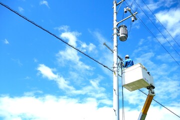 電柱の電気復旧工事をしている作業員	